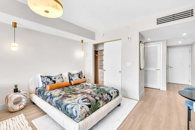 Bed with tropical print bedding next to the closet
