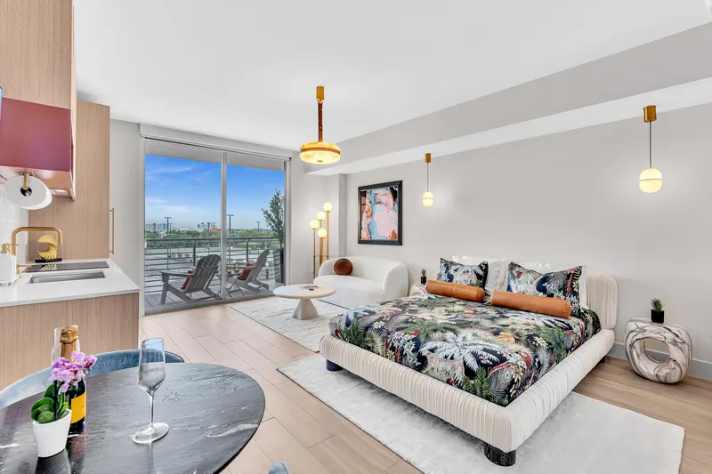 Champagne and glasses on the marble dining table, with the bed and balcony behind