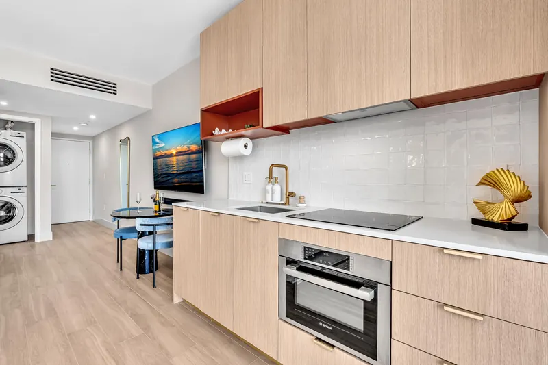 Kitchen counter with a gold faucet, built-in oven and a gold sculpture