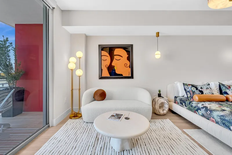 Curved white sofa, round coffee table, gold floor lamp and framed artwork